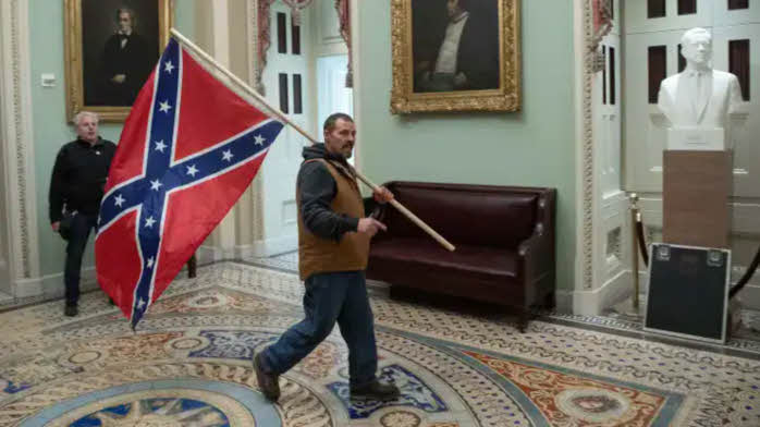 Rioter carrying Confederate flag in the U.S. Capitol.